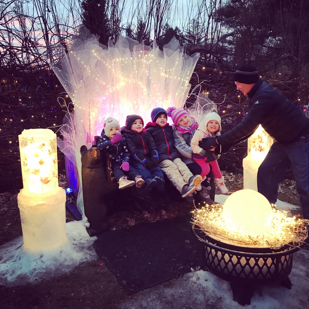 Children posing for picture near ice lanterns.